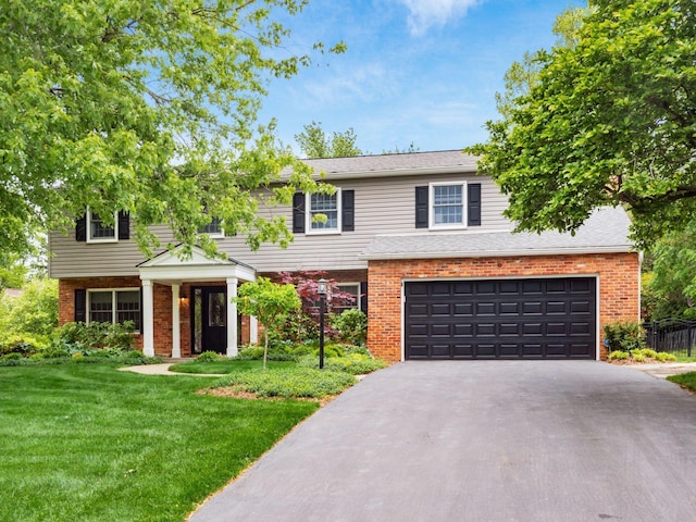 view of front of property with a garage, driveway, brick siding, and a front yard