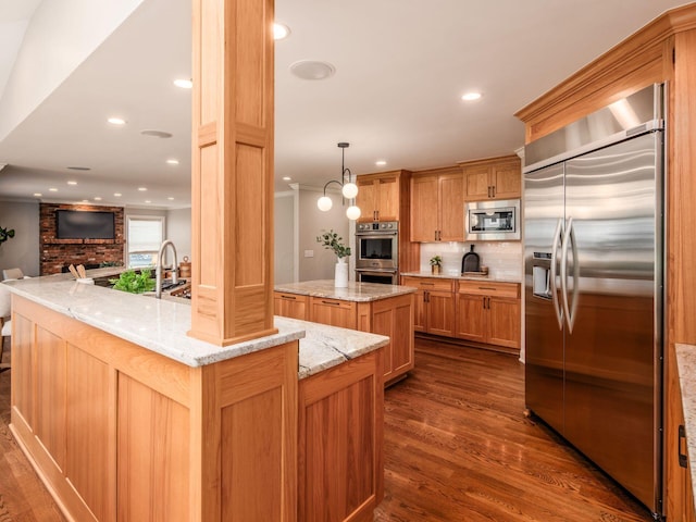 kitchen featuring built in appliances, a kitchen island, dark wood-style flooring, backsplash, and a sink