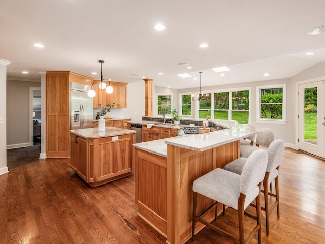 kitchen with appliances with stainless steel finishes, a sink, a spacious island, recessed lighting, and dark wood finished floors