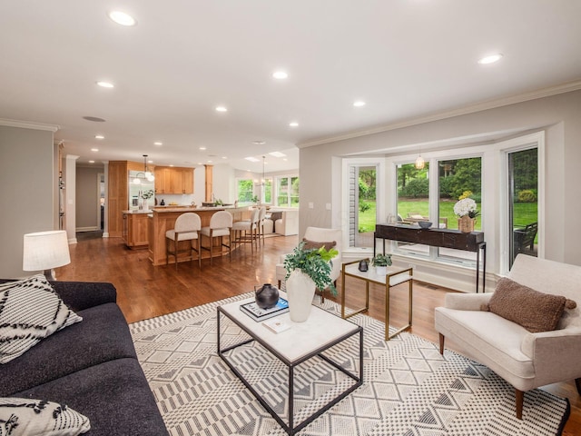 living area featuring ornamental molding, recessed lighting, and light wood finished floors