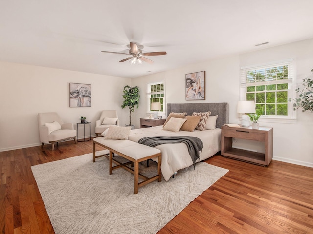 bedroom with light wood finished floors, baseboards, and a ceiling fan