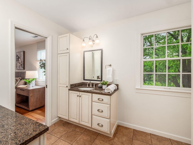 bathroom featuring vanity, baseboards, and tile patterned floors