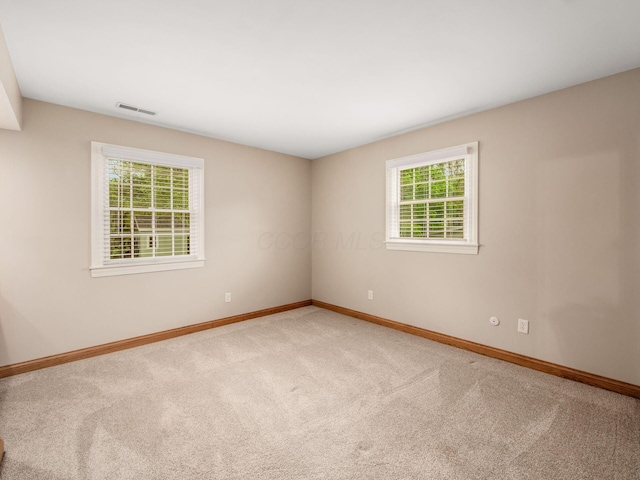 carpeted spare room featuring baseboards