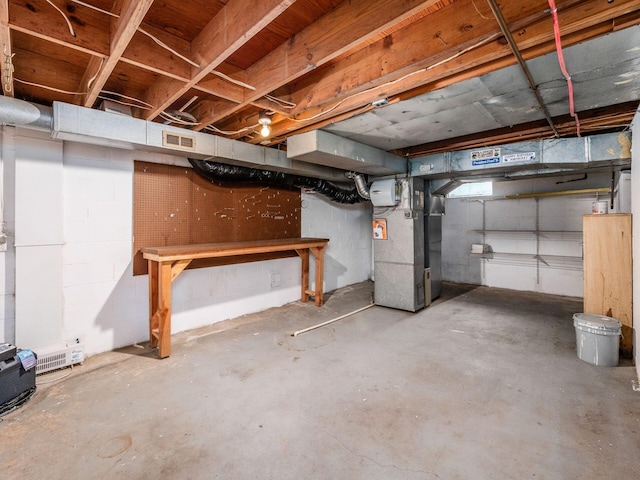 unfinished basement featuring heating unit