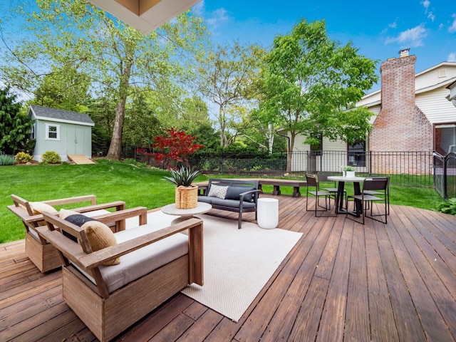 wooden terrace featuring outdoor lounge area, an outbuilding, a storage unit, and outdoor dining area