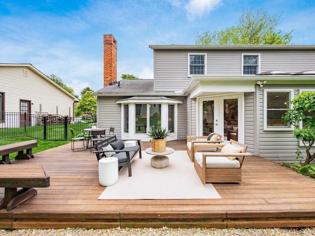 deck featuring french doors, fence, and an outdoor living space