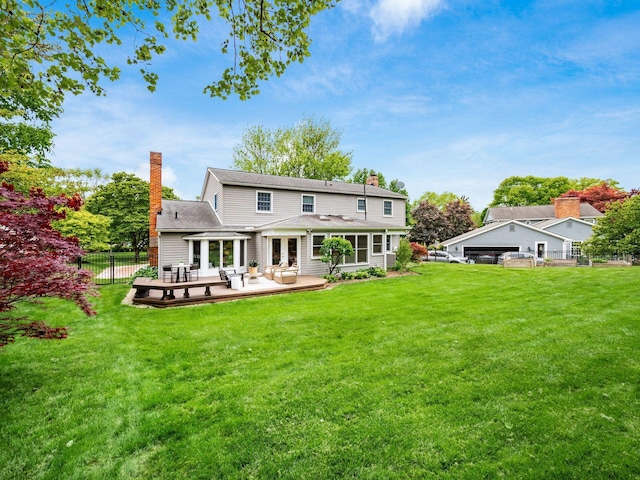 rear view of property with a chimney, a sunroom, and a deck
