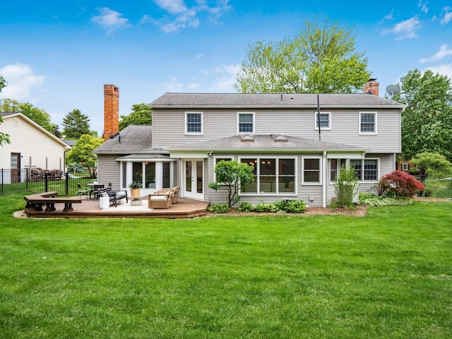 back of property with a chimney, outdoor lounge area, french doors, and a wooden deck