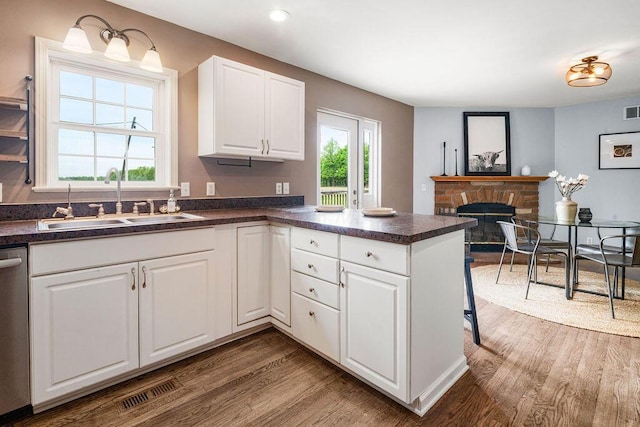 8950 Woodhaven Rd, Johnstown, OH 43031 - kitchen featuring a sink, wood finished floors, dark countertops, a peninsula, and white cabinetry