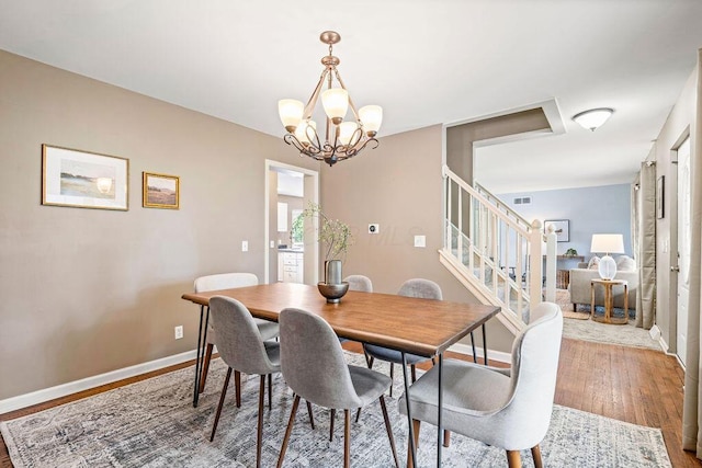 8950 Woodhaven Rd, Johnstown, OH 43031 - dining space featuring wood finished floors, a chandelier, stairs, and baseboards
