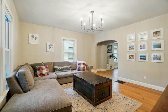 1545 Westwood Ave, Columbus, OH 43212 - living room with arched walkways, a chandelier, healthy amount of natural light, and light wood-style floors