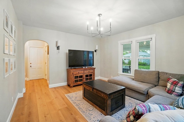 1545 Westwood Ave, Columbus, OH 43212 - living area featuring light wood finished floors, a chandelier, baseboards, and arched walkways