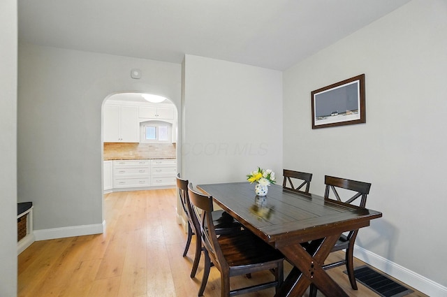 1545 Westwood Ave, Columbus, OH 43212 - dining area featuring light wood finished floors, baseboards, and arched walkways