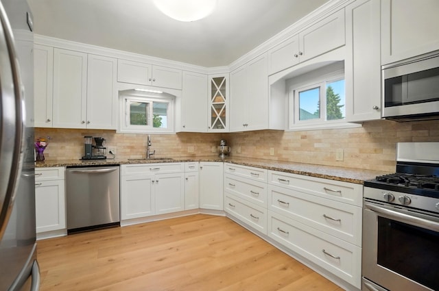 1545 Westwood Ave, Columbus, OH 43212 - kitchen with stainless steel appliances, a sink, white cabinetry, and backsplash