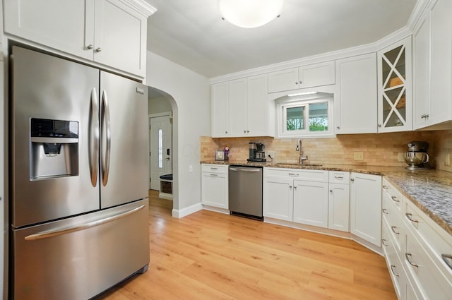 1545 Westwood Ave, Columbus, OH 43212 - kitchen featuring stainless steel appliances, a sink, arched walkways, decorative backsplash, and white cabinets