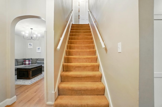 1545 Westwood Ave, Columbus, OH 43212 - staircase with arched walkways, wood finished floors, baseboards, and a chandelier