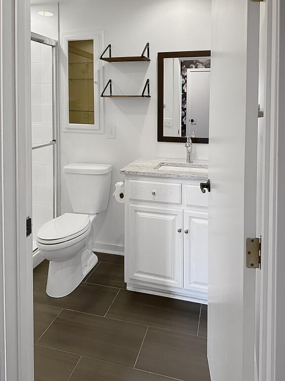 432 E Rich St Unit 3K, Columbus, OH 43215 - full bathroom featuring toilet, vanity, baseboards, and tile patterned flooring