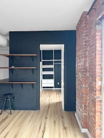 432 E Rich St Unit 3K, Columbus, OH 43215 - unfurnished living room with brick wall and light wood-style flooring