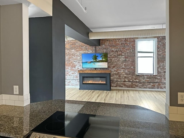 432 E Rich St Unit 3K, Columbus, OH 43215 - living area with a glass covered fireplace, wood finished floors, and brick wall