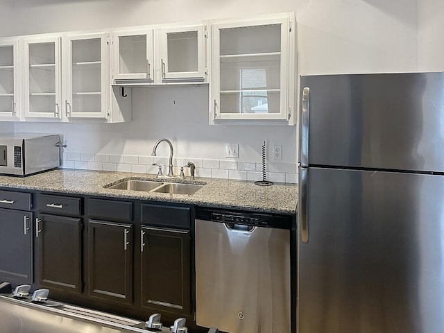 432 E Rich St Unit 3K, Columbus, OH 43215 - kitchen featuring stainless steel appliances, a sink, glass insert cabinets, and light stone countertops