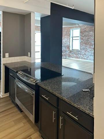 432 E Rich St Unit 3K, Columbus, OH 43215 - kitchen featuring stainless steel electric range, light wood-type flooring, and dark stone countertops