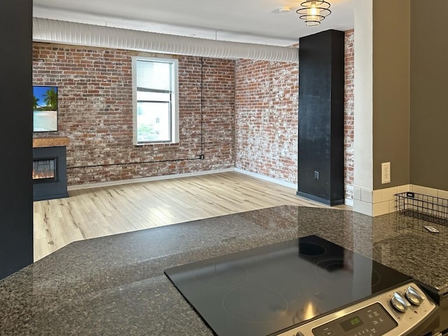 432 E Rich St Unit 3K, Columbus, OH 43215 - interior space with brick wall, stainless steel electric range oven, wood finished floors, dark countertops, and baseboards