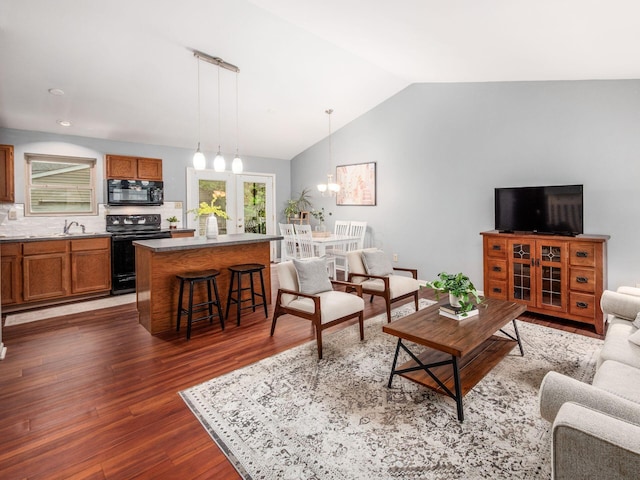 living area featuring a chandelier, dark wood-style flooring, and lofted ceiling