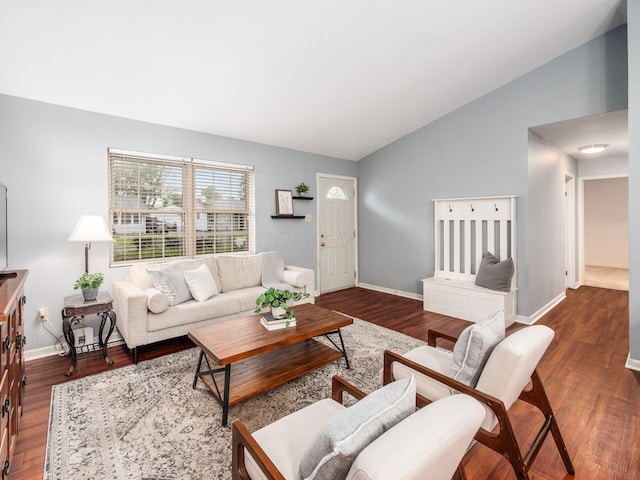 living area featuring vaulted ceiling, wood finished floors, and baseboards