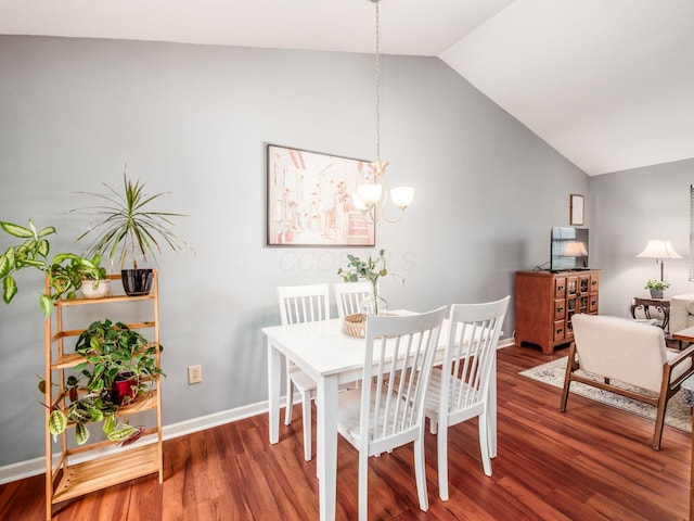 dining room featuring vaulted ceiling, a chandelier, wood finished floors, and baseboards