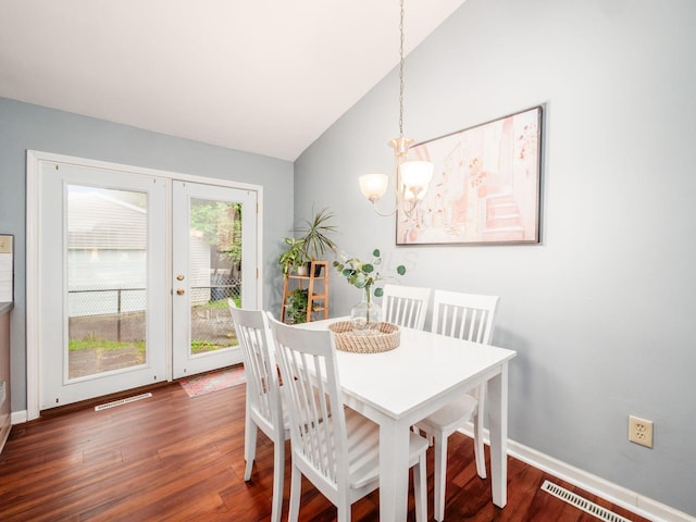 dining area with a chandelier, vaulted ceiling, wood finished floors, baseboards, and french doors