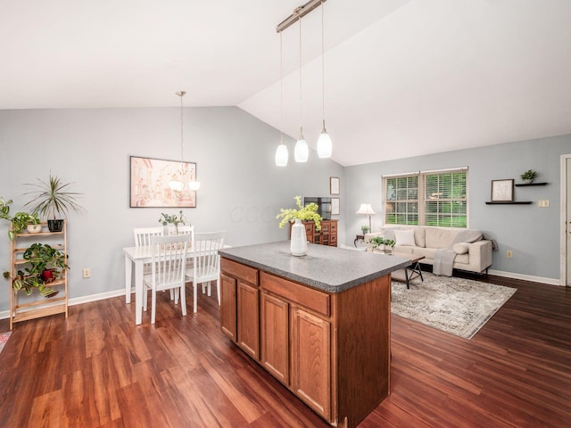 kitchen featuring lofted ceiling, a chandelier, a center island, dark wood-style floors, and brown cabinetry