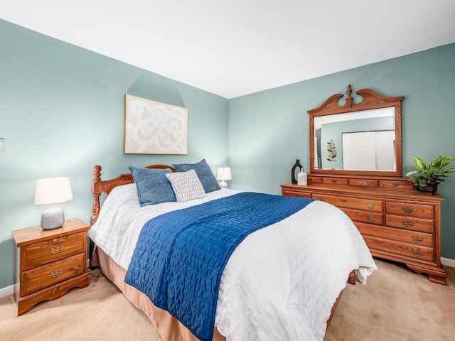 bedroom featuring light colored carpet and baseboards