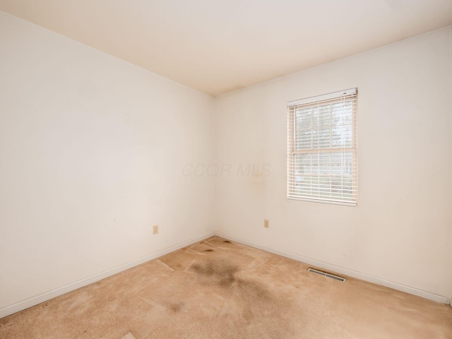 empty room with light colored carpet and baseboards