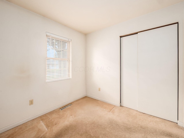 unfurnished bedroom featuring carpet, a closet, and baseboards