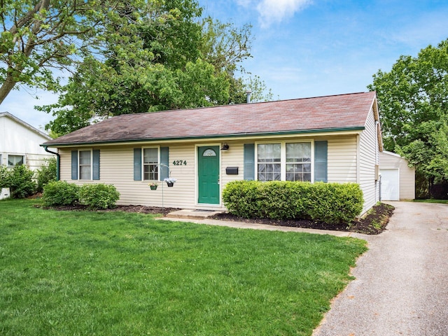 ranch-style home featuring a front lawn, a garage, and a shingled roof