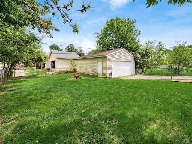 view of yard with a detached garage and an outbuilding