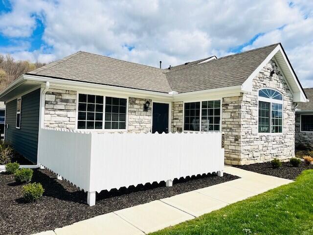 732 Whitetail Loop, Newark, OH 43055 - view of front of property with stone siding, fence, and a shingled roof