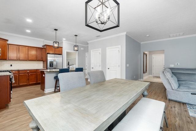 243 Parkgate Ct, Delaware, OH 43015 - dining area featuring light wood finished floors, ornamental molding, recessed lighting, a chandelier, and baseboards