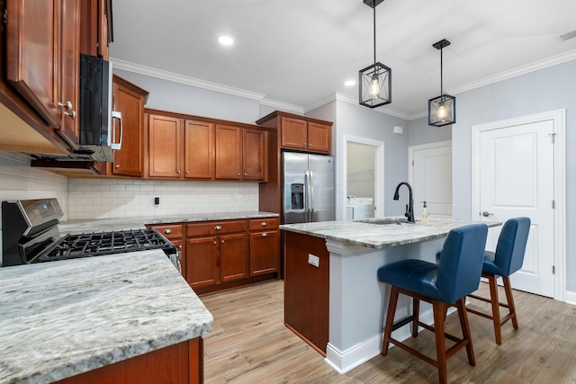 243 Parkgate Ct, Delaware, OH 43015 - kitchen featuring stainless steel appliances, a sink, brown cabinets, a breakfast bar area, and ornamental molding