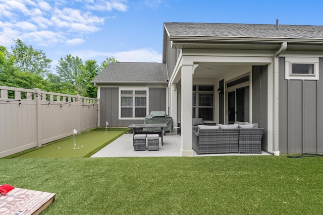 243 Parkgate Ct, Delaware, OH 43015 - rear view of house featuring board and batten siding, roof with shingles, a putting green, outdoor lounge area, and a patio area