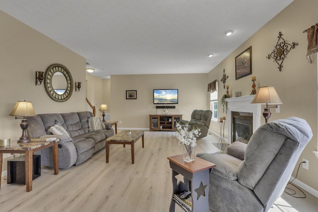 135 Tassel View St, Pataskala, OH 43062 - living room featuring a glass covered fireplace, light wood finished floors, and baseboards