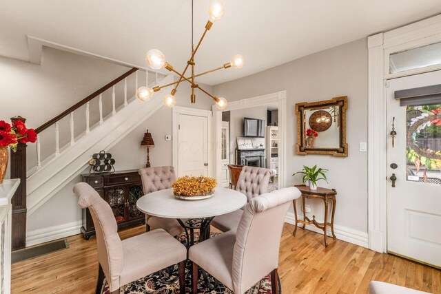1105 Say Ave, Columbus, OH 43201 - dining room featuring a chandelier, light wood finished floors, stairs, and baseboards