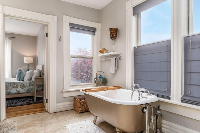 1105 Say Ave, Columbus, OH 43201 - bathroom featuring a freestanding bath, ensuite bathroom, tile patterned floors, and baseboards