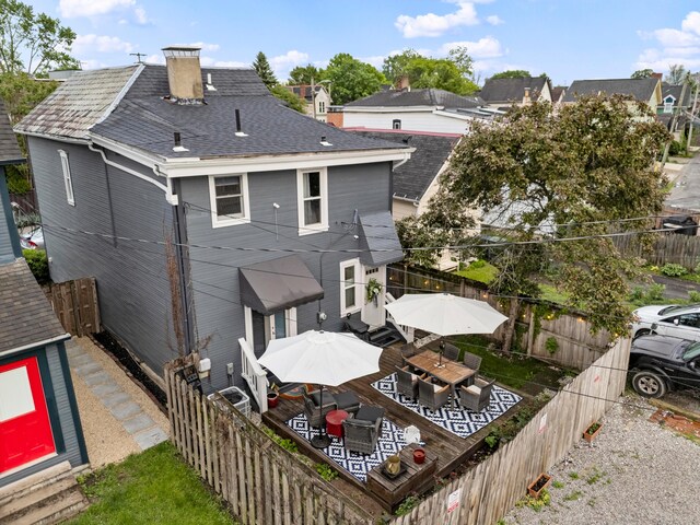 1105 Say Ave, Columbus, OH 43201 - rear view of house with a fenced backyard, a chimney, outdoor dining area, and a shingled roof