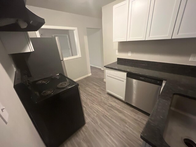 1227 Hart Rd, Columbus, OH 43223 - kitchen with appliances with stainless steel finishes, range hood, white cabinetry, baseboards, and dark stone countertops
