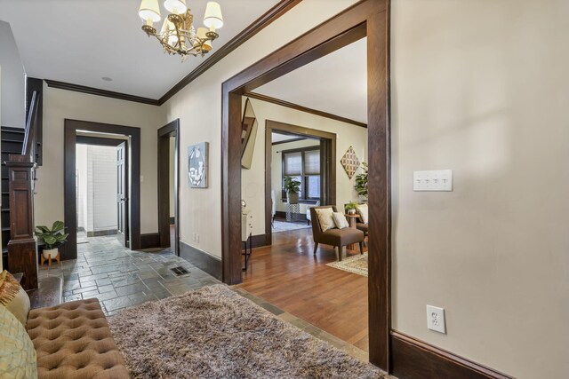 1041 Franklin Ave, Columbus, OH 43205 - foyer entrance featuring crown molding, a chandelier, baseboards, and stone tile flooring