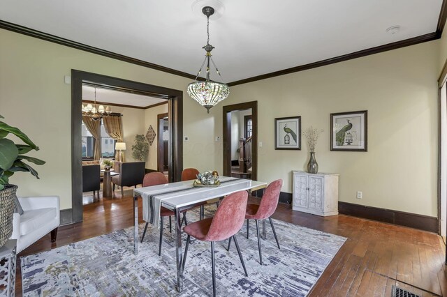 1041 Franklin Ave, Columbus, OH 43205 - dining room featuring a chandelier, hardwood / wood-style floors, crown molding, and baseboards