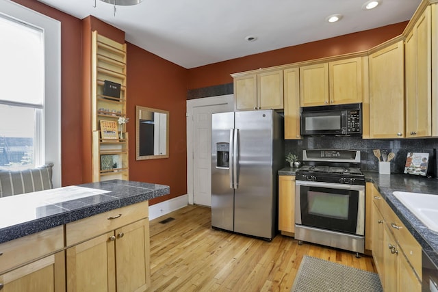 1041 Franklin Ave, Columbus, OH 43205 - kitchen with stainless steel appliances, tile counters, light brown cabinets, light wood finished floors, and recessed lighting