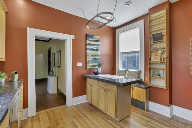 1041 Franklin Ave, Columbus, OH 43205 - kitchen with tile counters, light wood-style flooring, a chandelier, baseboards, and dishwasher