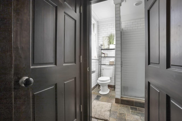 1041 Franklin Ave, Columbus, OH 43205 - full bath featuring toilet, stone tile flooring, a shower stall, tile walls, and crown molding